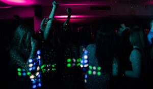 Energetic nightclub scene with people dancing under colorful neon lights. Perfect for nightlife themes.